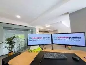 Puesto de trabajo con doble pantalla mostrando tulicitacionpublica. Com, asesoría online para preparar ofertas de licitaciones públicas